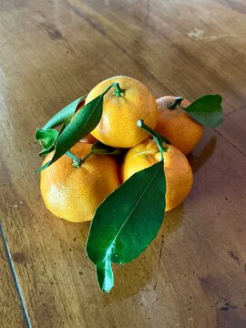 Group of Citrus sinensis (called jeruk baby santang) with leaves on wood background &ndash; local fresh fruit from Indonesia