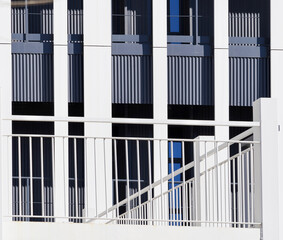 Fototapeta premium Modern Building Facade with White Railing and Vertical Elements
