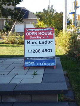Ottawa, Ontario, Canada &ndash; July 26, 2025: A REMAX "Open House" sandwich board for agent Marc Leduc sits on a stone patio near Riverside Drive in Ottawa on Riverside Rd.