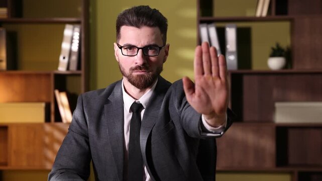Business man showing stop sign with his hand in office
