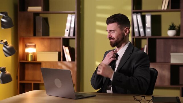 Overwhelmed man with laptop at desk in office