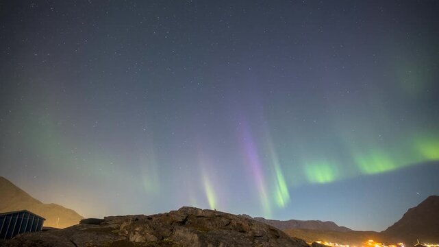 Timelapse of Northern Lights, Aurora Borealis dancing over ice fjord of East Greenland