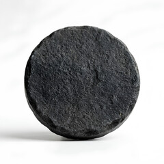 Fototapeta premium Closeup of a dark textured circular stone object on white background.