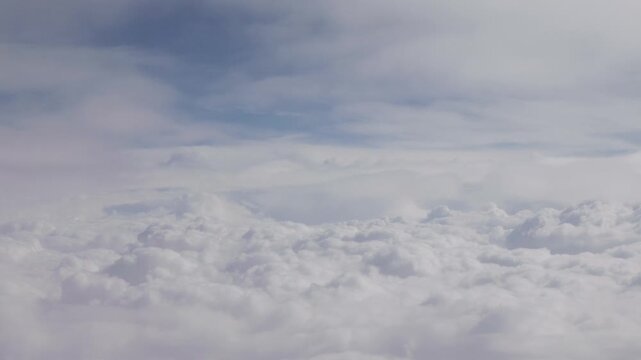 Beautiful white clouds and blue sky viewed from airplane window, 4k real time footage travel concept, b roll shot.