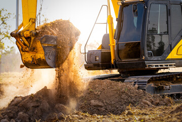 Close-up of excavator at construction site. Backhoe digging soil for earthwork and construction business. Excavating machine at work. Heavy machinery for earth moving and construction site development © Fahroni