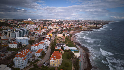 Fototapeta premium Aerial shot of Cascais coast with rolling waves and dramatic skyline