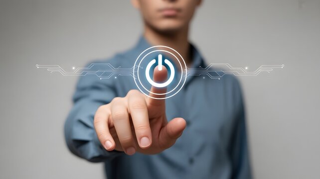 A persons finger presses a glowing digital power button in a technological interface