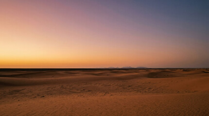 Obraz premium Vast desert sand dunes under a colorful sunset sky at twilight