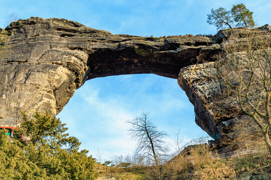 Majestic natural rock arch formation against blue sky in scenic landscape