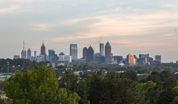 View of the Downtown and Midtown Atlanta Skyline Cityscape showing several prominent buildings, trees, and hotels on a beautiful clear night.
