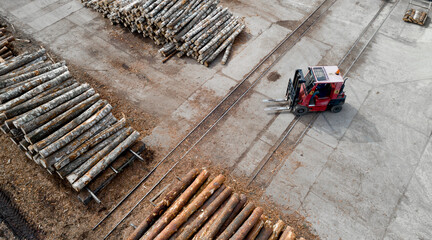 loader in a log warehouse at a woodworking enterprise top view. © Polivan