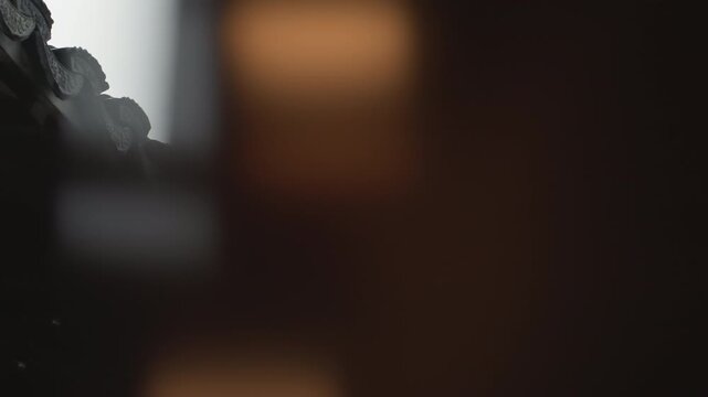 Ornate chinese temple roof with guardian statue overlooking courtyard, closeup of carved ridge and tiled eaves, overcast sky and muted palette, weathered patina and intricate dragon motifs, ceremonial