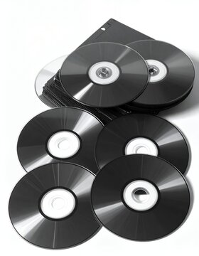 Stack of blank black CDs and DVDs on a white background, ready for data storage.