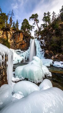 Stunning Winter Waterfall with Icy Formations and Snow-Covered Rocks.