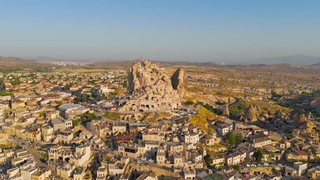 Uchisar, Nevsehir, Turkey. Morning aerial view of the majestic Uchisar Castle rock fortress and traditional cave houses in surrounding village.. Aerial View