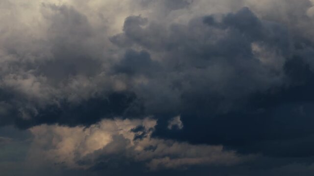 Timelapse of dark storm clouds moving rapidly across the sky as weather deteriorates before a thunderstorm, dramatic atmospheric buildup with dense thundercloud formations signaling approaching severe