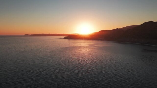 Aerial low panning shot of Paradise Cove at Point Dume during sunset in Malibu, California. 4K