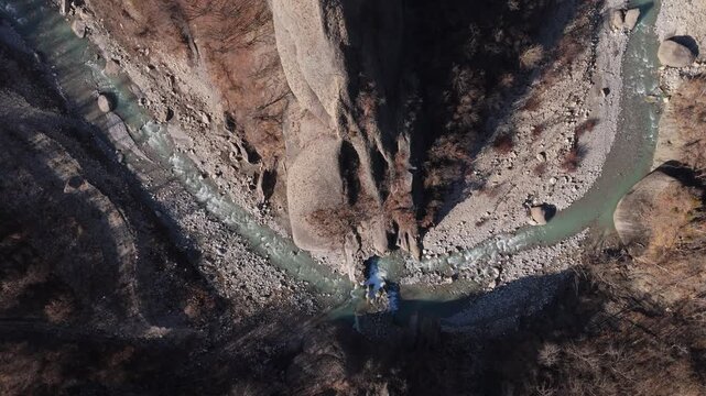 Zoom out aerial from river revealing canyon and Salti del Diavolo rock formations.