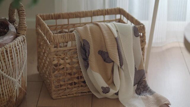 Cozy blanket on a basket next to a table