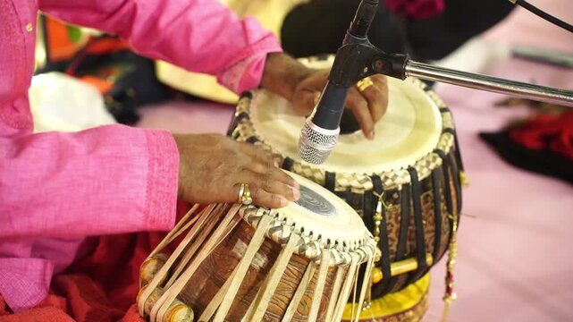 A tabla player performing live classical music at a traditional Indian wedding reception, featuring authentic ethnic instruments