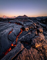 Naklejka premium Molten Lava Flowing Through Volcanic Landscape at Sunset.