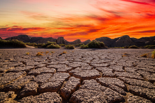 Dramatic sunset over parched and cracked earth in an arid desert landscape