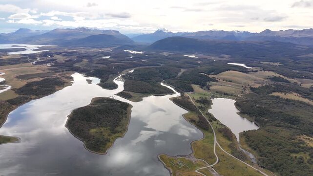 Cinematic aerial raising over the intricate waterways of Bahia Harberton to reveal the rugged Patagonian wilderness and snow-capped Andes mountains in Argentina
