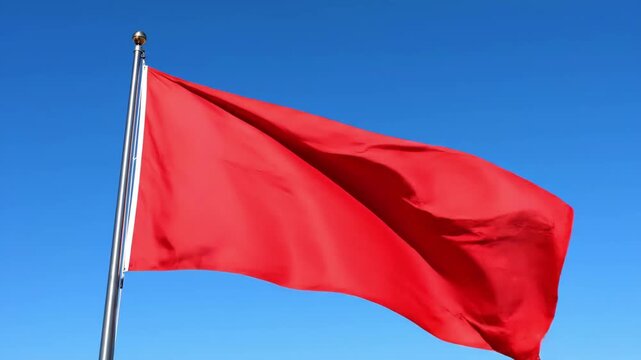 Red flag waving on silver pole.