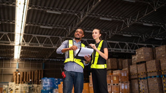 Warehouse manager talking and checking product in warehouse.
