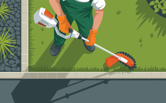 A man in green overalls uses a lawn edger on a grassy lawn.