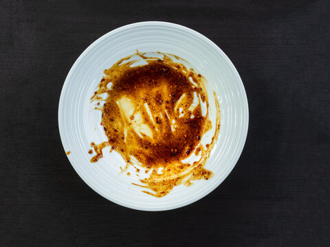 Dirty plate top view background, finished eat dinner in restautant, abstract textuer stain smearing drip sauce bbq jam chilli jelly on ceramic breakfast, concept for clean hyginene product