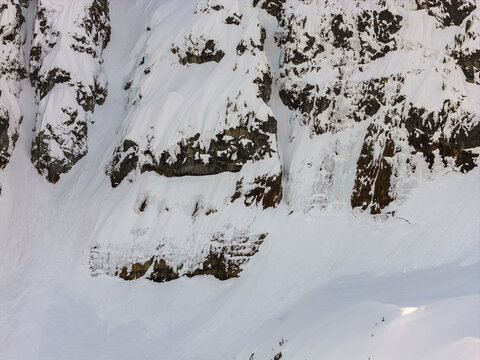 Snow-Covered Rocky Mountain Cliffs and Steep Slope in British Columbia, Canada Winter Landscape