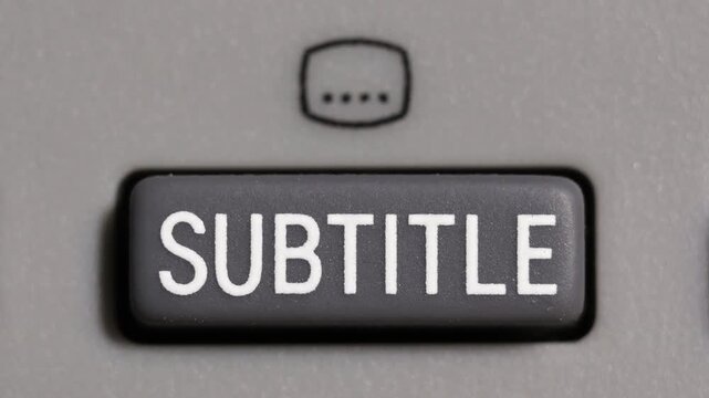 Finger presses gray subtitle button with white text and icon on light gray remote