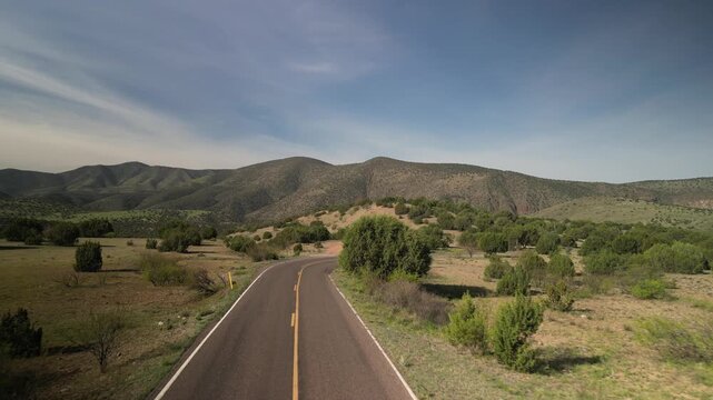 Low aerial in Gila National Forest over two lane road in San Francisco Mountains near Reserve New Mexico in spring