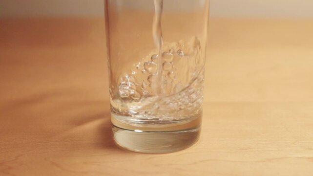 Water Forever Pouring Into Glass Creating Ripples - Looping Video