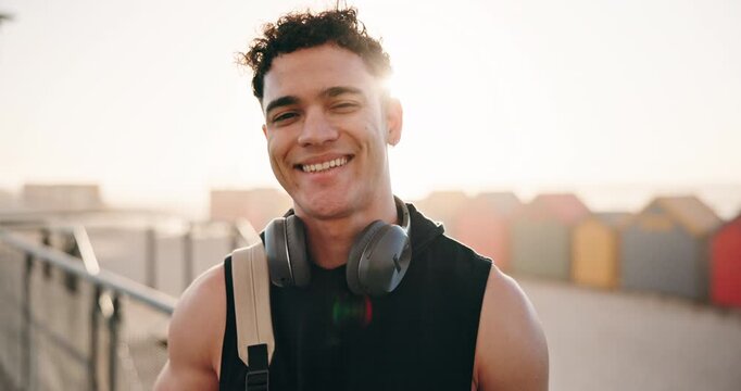 Happy, fitness and face of man outdoor with headphones for exercise, training and workout for wellness. Sunlight, runner and portrait of person with backpack for challenge, health and active hobby