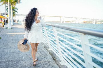 Latina woman enjoying summer travel on waterfront promenade © Ivan Muñoz Colorado