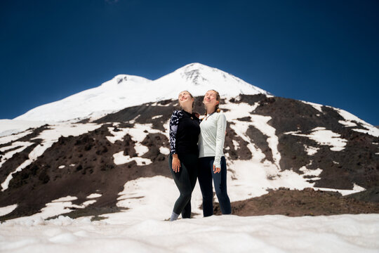 The two young women enjoyed an active summer in snowy mountains together during an acclimatization trek on a sunny day.