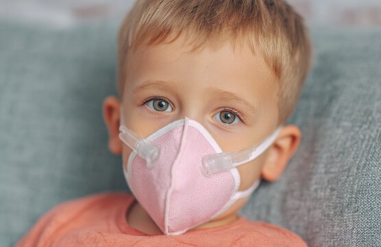 During a pediatric dentistry visit, a young boy wearing a pink nasal mask inhales nitrous oxide in the dental chair, is sedated for a dental procedure, and feels calm and relaxed