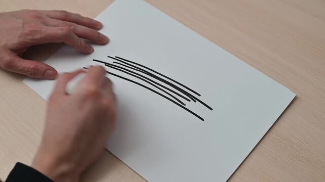 A hand demonstrates different drawing techniques using a marker on paper. The process includes creating various types of lines, suitable for tutorials or creative projects