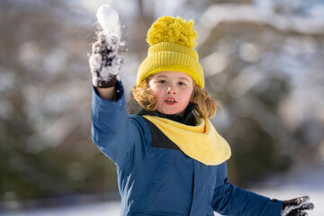 Kid face portrait during winter play. Winter child face portrait in snowy park. Kid portrait with...