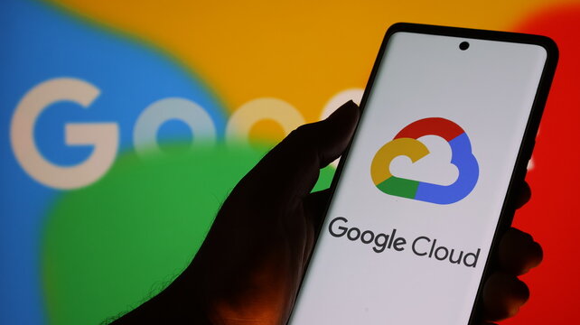 Hand holding smartphone with google cloud app on screen in front of google logo background