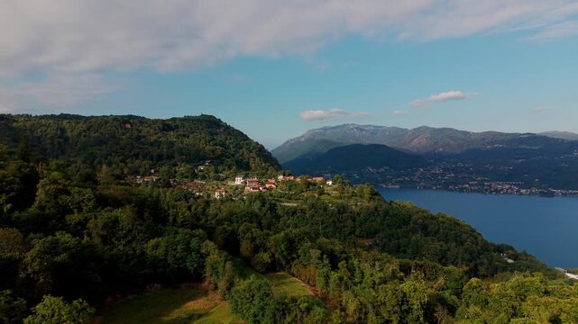 Alzo, Baveno, Piedmont, Italy - A Picturesque Village Offering a Scenic View of Lush Greenery, Overlooking Lake Maggiore With Mountains in the Background - Aerial Drone Shot