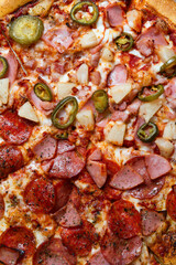 Overhead Fresh Delicious Pizza with Pepperoni, Ham, Pineapple and Jalapeno