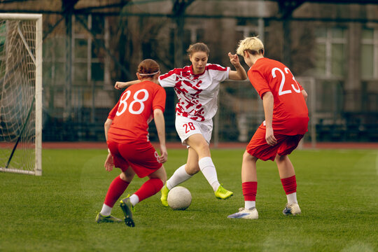 Young woman soccer players play football.