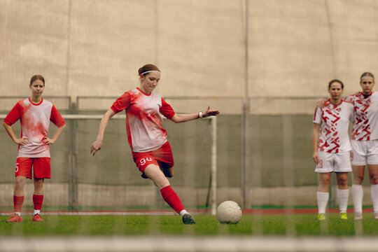 Young woman soccer players play football.