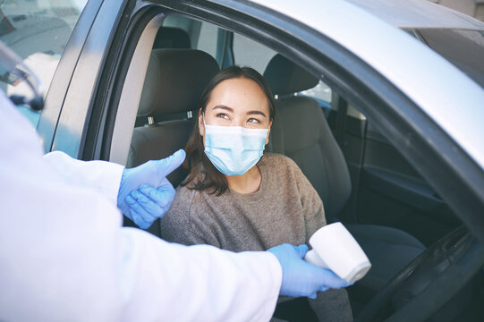 Face mask, thermometer and thumbs up with people at drive through for checkup, control or healthcare. Regulations, success and temperature with doctor checking patient at medical station for travel