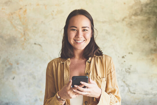 Smile, search and portrait with woman and phone for streaming, ebook app or social media. Digital library, chapter release schedule and contact with person on wall background for author notes and web