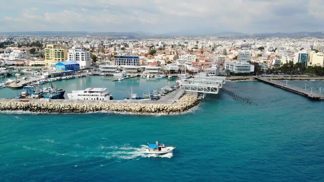 Aerial view of fishing boat sailing near limassol old port harbor during sunny day in cyprus island.