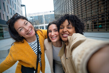 Diverse friends taking selfie together smiling in city